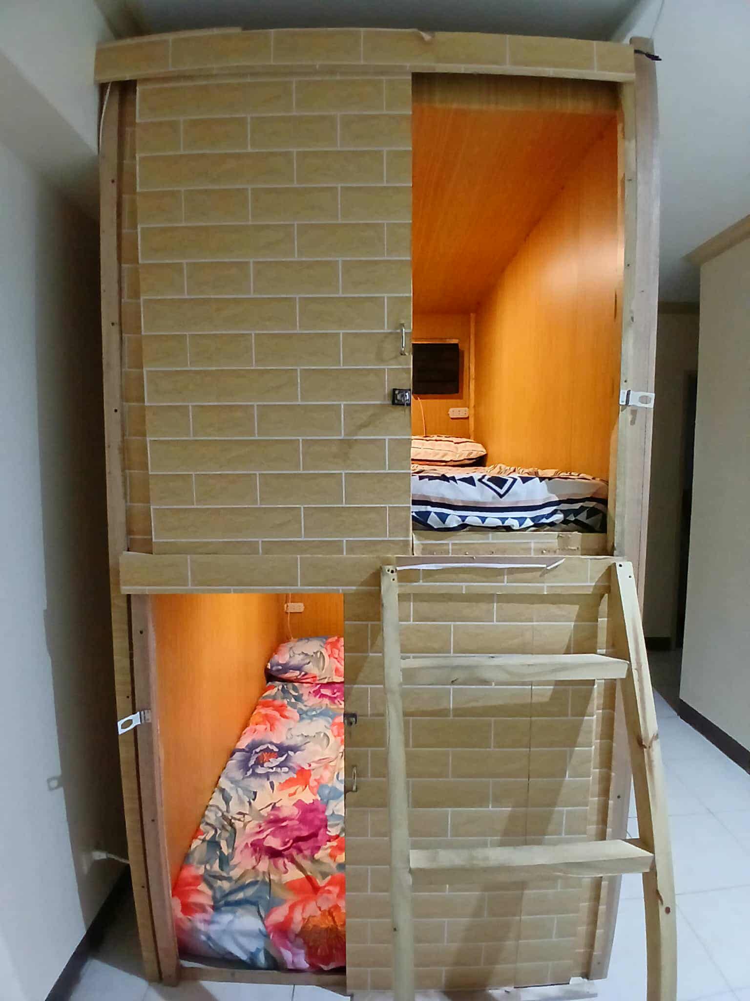 Bunk-style capsule pods with orange lighting and colorful bedding