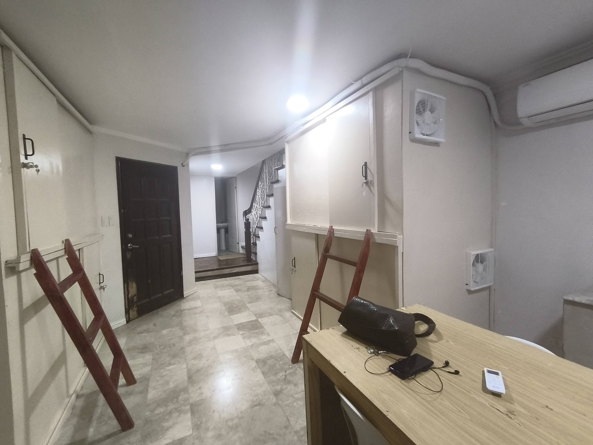 Capsule hotel hallway with reception area and pod ladders