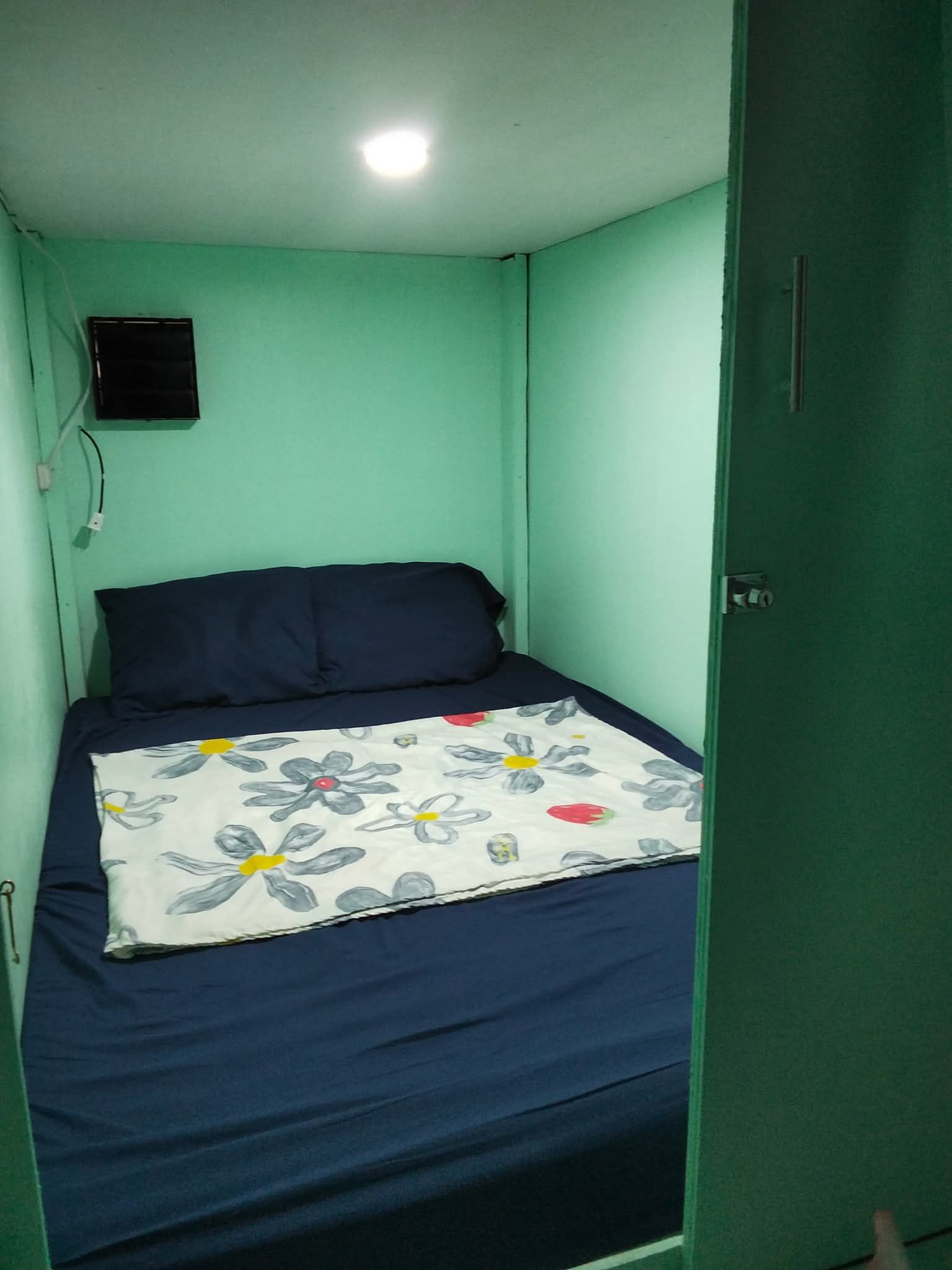 Cozy capsule room with navy blue bedding and mint green walls